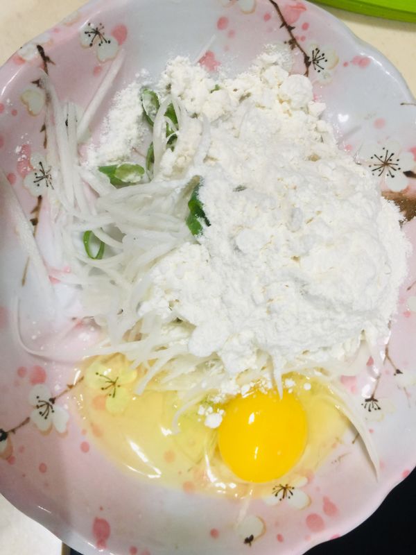 白蘿蔔刨成絲後加入蔥末和雞蛋ㄧ顆，蘿蔔絲越多蔥末和雞蛋可增加⋯⋯加入低筋麵粉2大匙（麵粉視食材多寡自行做調整）