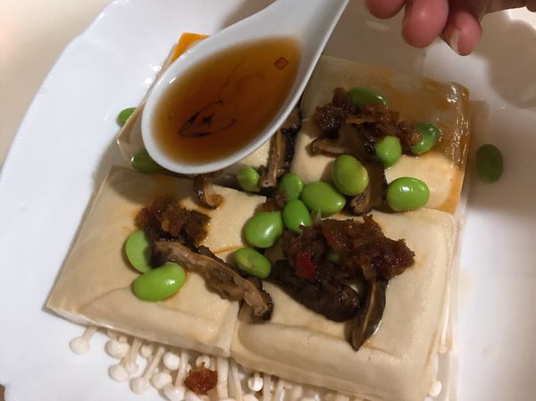 放上毛豆仁、香菇後，在每塊臭豆腐上都放一小湯匙XO干貝醬，再淋上淡醬油。

**若喜歡吃辣可以再加辣油或辣豆瓣醬。