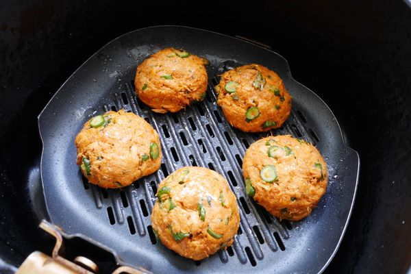 專用煎烤盤上噴少許油，放入5顆魚餅，再在魚餅表面噴油。