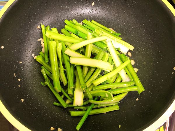 倒入橄欖油 將蒜頭爆香
再放入油菜花的梗拌炒
加入少許的水蓋上蓋子悶煮到7分熟