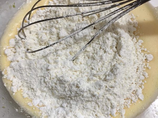 過篩低筋麵粉、泡打粉於步驟一的蛋黃液中。