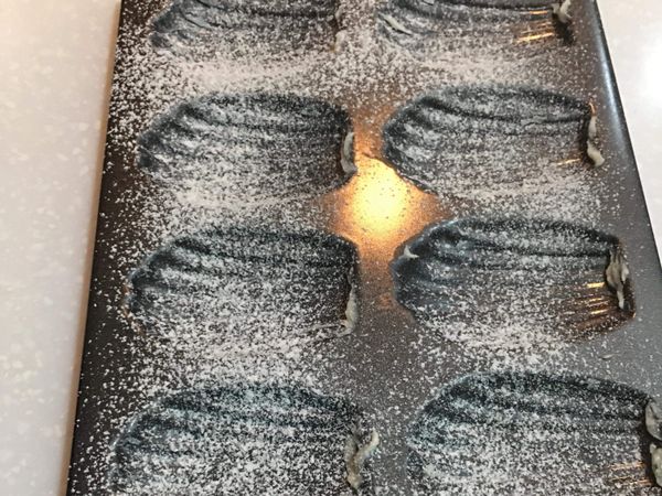 將瑪德蓮模具取出，先抹上一層奶油，接著過篩少量的低筋麵粉於模具上備用。