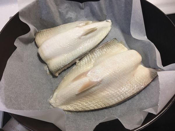 1.平底鍋上鋪料理紙，開小火熱鍋。
2.將虱目魚肚洗淨，用廚房紙巾吸乾水分。
3.魚肉面朝下，放入鍋內。