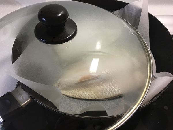 用中小火煎虱目魚肚，以鍋蓋稍加遮蔽，避免被油噴。