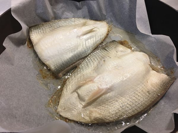輕壓魚背，使魚肚平貼鍋，中小火續煎，待魚肚油脂釋出。