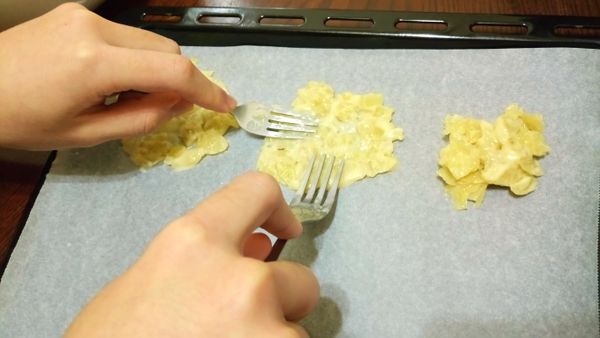 將入味的杏仁片拿叉子挖一點在烘培紙上，再用叉子慢慢推開（可用叉子沾點水比較好推開）