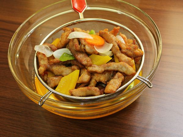 將油溫升高, 倒入肉條回炸, 蔬菜一起加入, 大火油炸, 將多餘水份逼出, 將鍋內食材倒至濾網上, 瀝掉多餘油脂