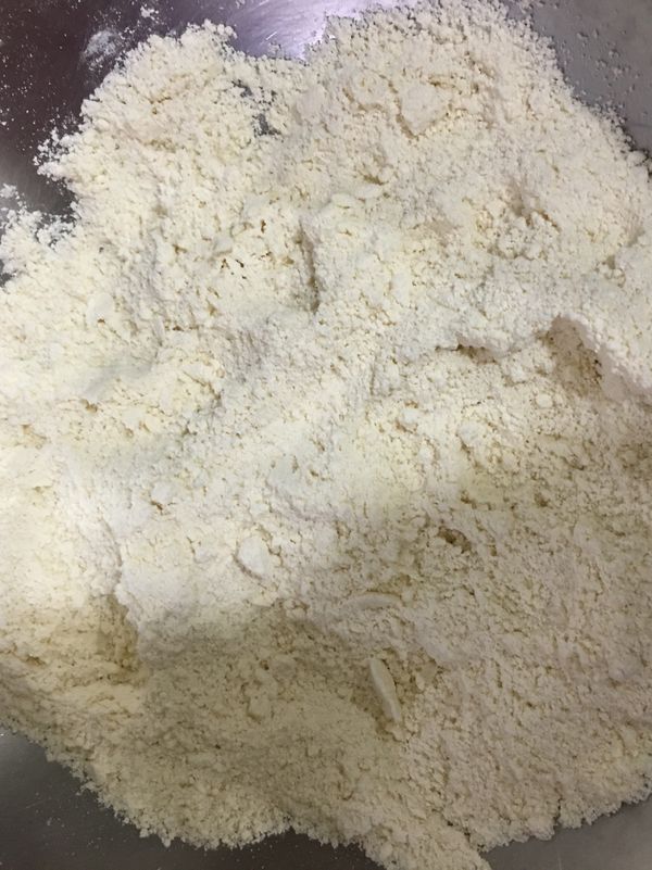 將冰硬的奶油加入粉類食材後，用手指將兩者搓揉混合成砂粒狀