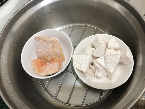 先把南瓜跟芋頭用電鍋蒸熟，電鍋外面放一杯水