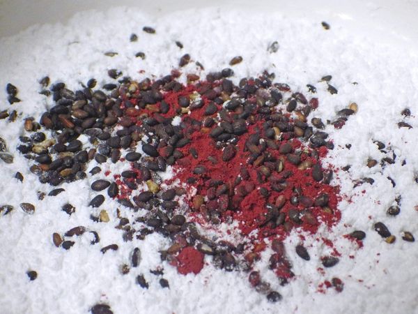 準備一小鍋煮沸的開水（熱水器裡的熱度不夠，一定要準備滾燙的熱水，成功率較高）接著把地瓜粉+太白粉及紅麴粉，黑芝麻拌勻後一大匙的沸水加入粉中攪拌，再慢慢添加沸水揉麵糰