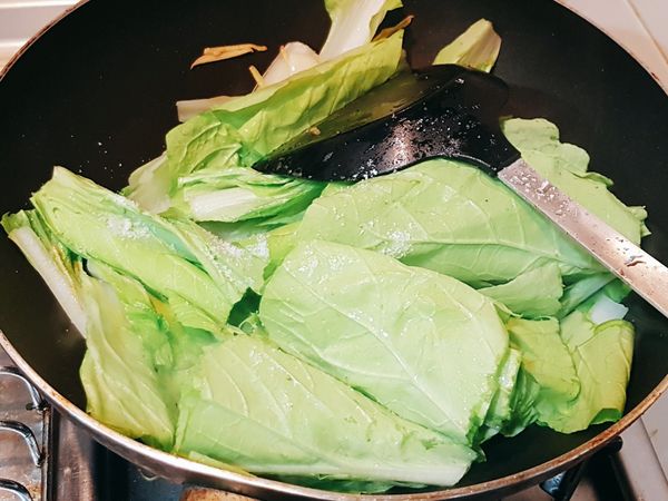 大火放入小白菜，先加入梗梗，再加葉菜，然後放鹽巴後快炒