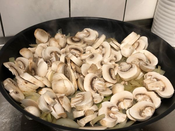 洋蔥炒軟後放入蘑菇拌炒，一樣炒軟