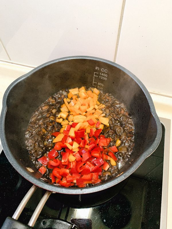 加一碗水與薑末/蒜末，煮一下後
將紅、黃甜椒加入拌炒