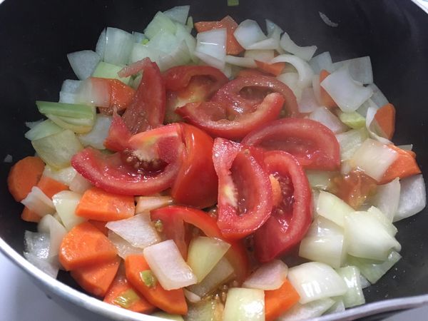 將食材撥到鍋邊，在中間放入蕃茄，煎至蕃茄軟爛，再翻炒。（如下圖）