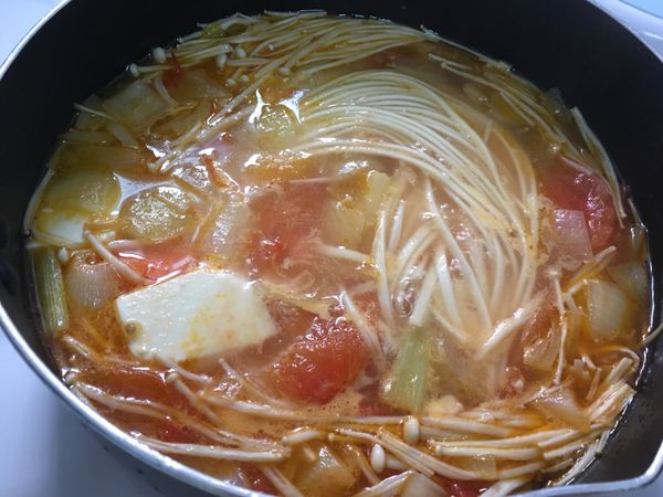 倒入一碗雞高湯，再加水至想要的高度。
然後加入豆腐、金針菇一起煮。
水滾後，加入鹽巴調味，並放入麵條。