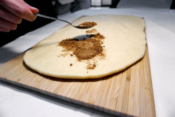 取出麵團均勻桿平成長方形，並均勻灑上烤過的堅果碎與先前混合的肉桂黑糖，記得在一邊長邊預留1公分不灑內餡。（此配方沒有很甜，喜歡甜可以酌量增加）
⟡Tips 堅果可以先進烤箱180度烤3-5分鐘會更香！
也能先均勻塗抹常溫奶油後再灑肉桂糖、堅果，會多一個更濃的香氣！但今天示範的版本沒再塗抹奶油哦！