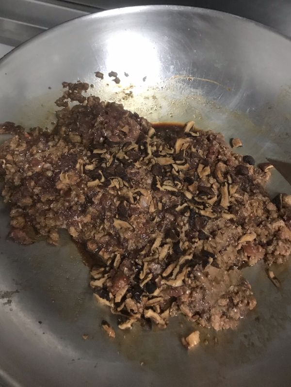 加入香菇丁繼續拌炒的至肉熟透