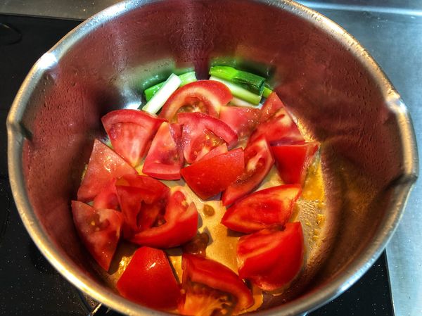 加入蕃茄拌炒（茄紅素經油炒釋放出來），待炒到油色變得橘紅色後就加入適量的水煮至沸騰