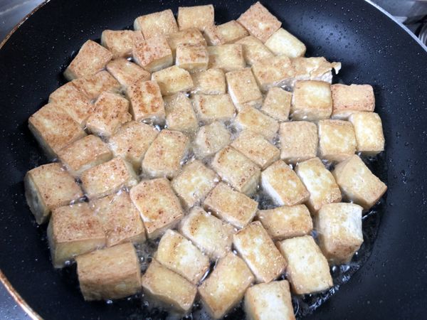 豆腐切塊，兩面煎金黃。也可以直接用油豆腐代替。