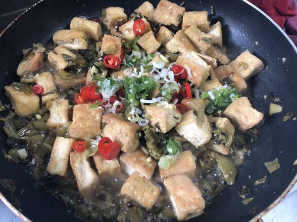 酸菜切小塊，加入花椒、酸菜末、薑末、辣椒，用小火爆香後，加入一碗水煮滾，再倒入豆腐、醬油、二砂，中小火煮至入味收汁。起鍋前加點蔥末，即可上桌。