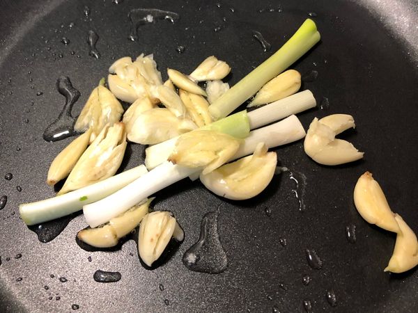 熱鍋下一大匙油放入蒜頭和白蔥段，炒出香氣
