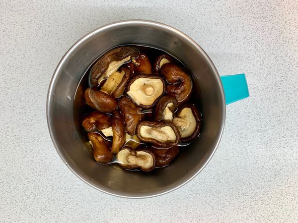 香菇用溫水泡軟後切片備用
（在溫水中加少許砂糖
因砂糖吸水速度變快
延緩了鮮味的溶出
理由是糖水的滲透壓比淡水高
和內部的濃度差較少
所以成分的溶出會變慢）