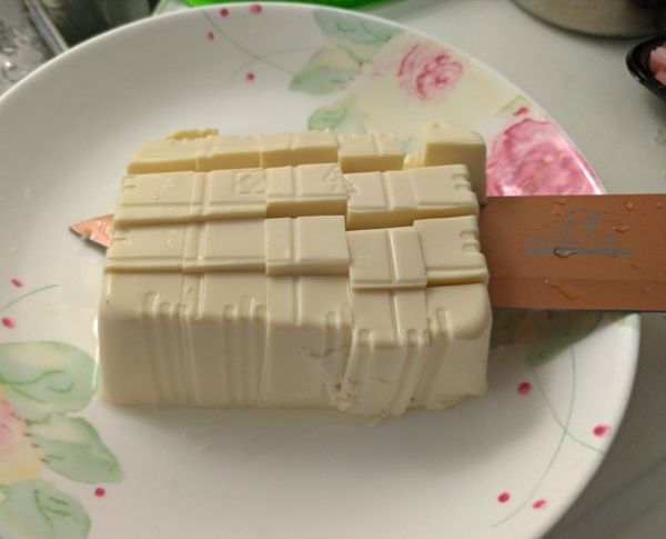 利用煮小魚乾的時間來切豆腐，將豆腐倒扣在盤中會比較好切，咪樂媽的撇步是先劃直線再橫剖，刀子切入後慢慢轉一圈，會比較好切。