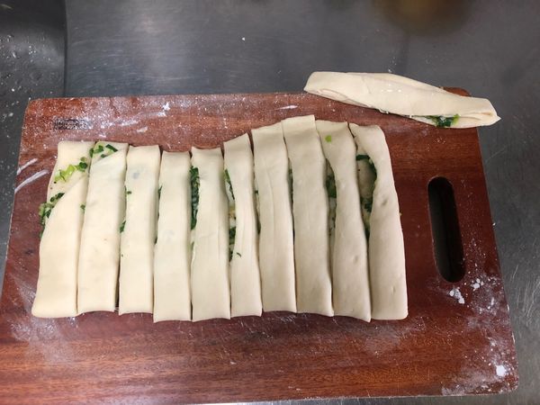 舖完後稍微在上面輕輕拍壓拍壓一下，
轉成橫向，切成10等份，本想切12分，
結果少一份，
所以有一條孤兒先放旁邊納涼🤣