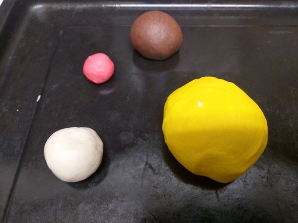 取攪拌好的麵糰250克用黃色色粉調出身體和頭部的麵糰,20克麵糰用可可粉調出線條和眼睛還有觸角的麵糰,10克麵糰用紅色色素調出嘴巴的麵糰,剩餘麵糰用來作翅膀.靜置30分鐘備用