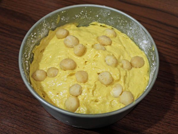 麵糊填入烤膜中, 再抹平表面, 輕震幾下讓裡頭空氣跑出來, 均勻鋪上夏威夷豆