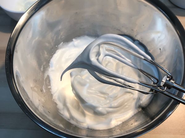 將蛋白打至乾性發泡。砂糖分兩次加入，蛋白打出大泡泡時，加入一半砂糖，打成細白泡泡時加入另一半砂糖。