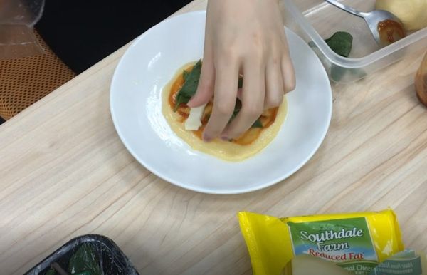 把起司撕成條狀和九層塔一起放上麵團，微波一分半