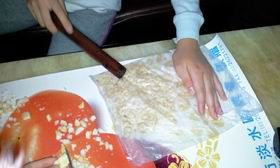 2、熟花生先用桿麵棍敲成小顆(不可太碎)放入小烤箱預熱(備用)