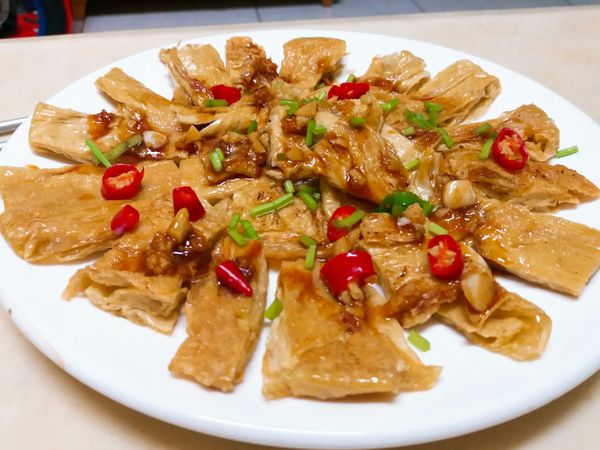 醬汁調勻，不能一下子全部倒入，怕會過鹹，用小湯匙一小匙一小匙淋適當量在豆皮上，加點香菜末，酸香辣開胃。