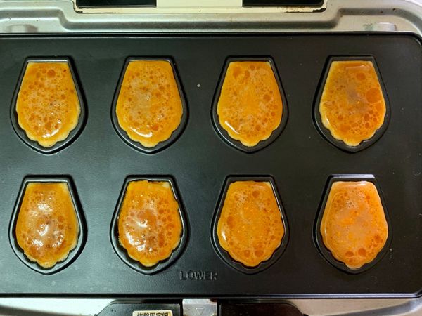 將熱壓機開機，約一分鐘後，用湯匙把攪拌好的材料放入烤模裡（放平或89分滿也可）