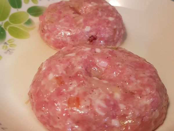 挖一大匙拌好的絞肉於手中
雙手交替左右甩肉（大概十次）
放置剛剛抹好油的容器塑形並在正中間壓一點凹陷