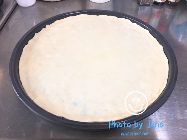 取出麵糰，用桿麵棍將麵糰來回桿成圓形，盡量將麵皮平均桿平桿薄。烤盤事先塗抹一層薄薄的橄欖油，然後將麵皮鋪在烤盤上，並將周圍拉整到邊緣。