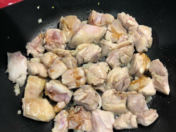 蒜頭爆香後將雞肉下鍋煎至金黃色後起鍋
