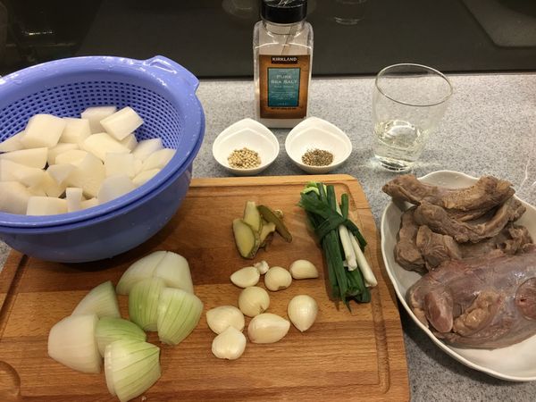 牛腱與牛腩用米酒加水川燙過，再洗去川燙後的屑屑備用，蘿蔔削皮後切成容易入口的大小，薑切片、蒜頭去皮、蔥洗淨捆好，將上述材料洗好切好備用。