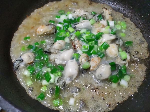 鍋中2大匙油燒熱,倒入蚵仔稍翻煎,再將調好的芡水淋上去,蓋鍋蓋燜一會,待芡水周邊變透明…