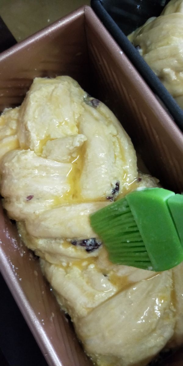 發酵高度約7-8分模，將額外材料中的蛋汁均勻塗抹至麵糰上