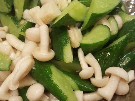 熱油鍋中小火爆香蒜末，丟入小黃瓜炒香，關小火，加入糖一小匙，米酒一大匙，加二三滴白醋悶到小黃瓜斷生，接著加入雪白菇，少許開水悶煮，至湯汁呈乳白色後，加入少許雞粉塩巴香油，就可以上菜囉