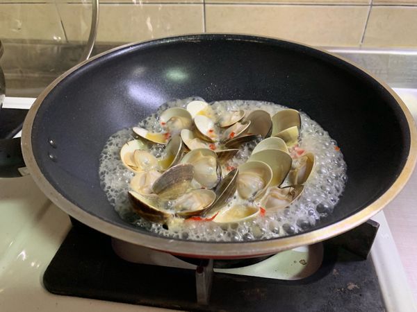 入蛤蜊再倒入白酒蓋鍋蓋讓蛤蜊開口