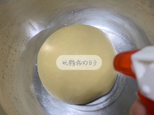 把麵團放入盆中噴點水蓋上保鮮膜發酵60分鐘。