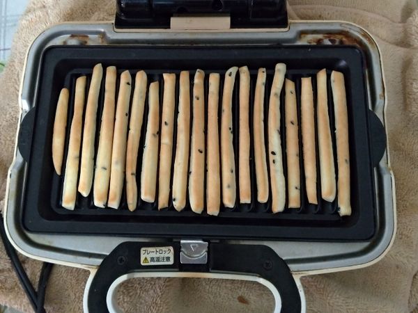 打開小v，用夾子將餅乾翻面，再蓋上烤三分鐘(不要用翻機翻面會倒的東倒西歪的)