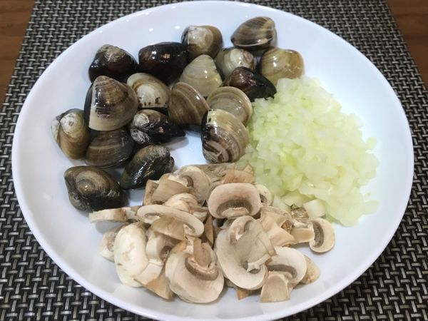 在等待醃漬蝦子的時候，將吐好沙的蛤蜊洗淨瀝乾、洋蔥和蒜頭切末、蘑菇切片