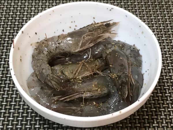 蝦子洗浄、去殻並保留頭尾部份、剪鬚、清腸泥後，放入少許的鹽、黑胡椒、羅勒，醃漬蝦子約10分鐘