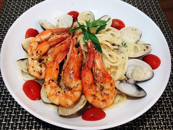 將麵撈起呈盤裝飾，並放入先前煎好的蝦子即完成