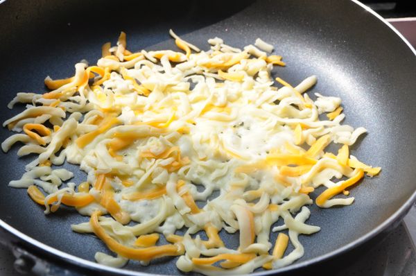 另外再將平底鍋擦拭乾淨加熱(不放任何一滴油)，均勻鋪放乳酪絲於鍋中再以中小火加熱