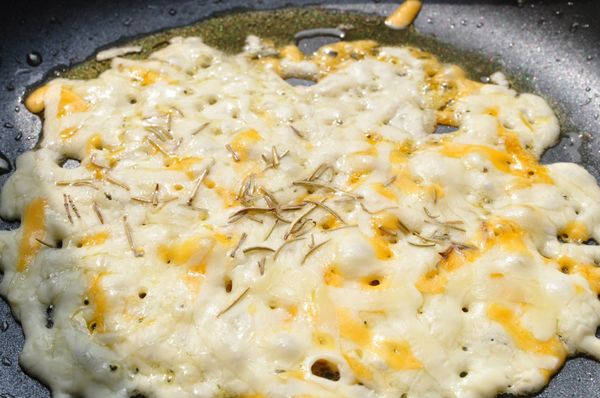 在乳酪絲均勻受熱起泡後，灑上適量的迷迭香